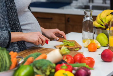 Pregnant woman in the kitchen cooking